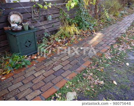 Approach of bricks colored with fallen leaves 98075648