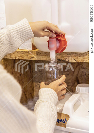 eco friendly habits hand gesture_refilling detergent at zero waste shop eco friendly habits hand gesture_refilling detergent at zero waste shop 98076163