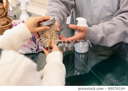 eco friendly habits hand gesture_a hand for a bottle of ingredients 98076184