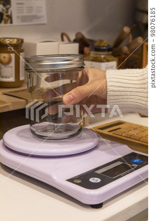 eco friendly habits hand gesture_refilling and weighing at zero waste shop 98076185