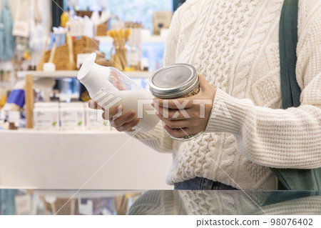 eco friendly habits hand gesture_holding a refill bottle 98076402