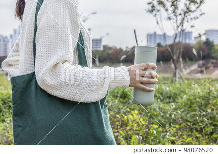 eco friendly habits hand gesture_holding a tumbler 98076520