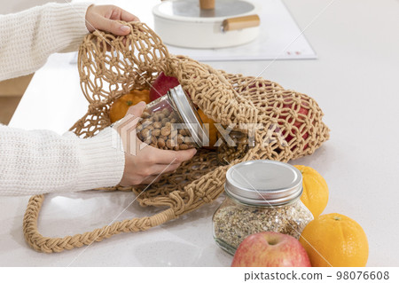 eco friendly habits hand gesture_taking out the ingredients from the shopping cart 98076608