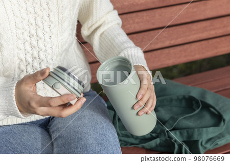 eco friendly habits hand gesture_using tumbler 98076669