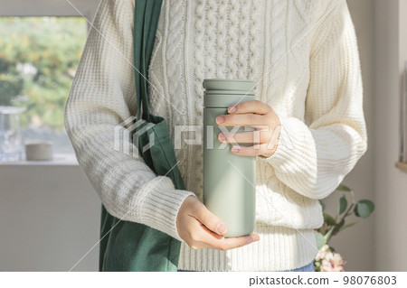 eco friendly habits hand gesture_wearing an eco bag and holding a tumbler eco friendly habits hand gesture_wearing an eco bag and holding a tumbler 98076803