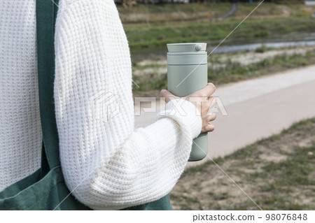 eco friendly habits hand gesture_holding a tumbler eco friendly habits hand gesture_holding a tumbler 98076848
