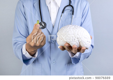 brain health and dementia series_docotr holding brain miniature and omega 3 brain health and dementia series_docotr holding brain miniature and omega 3 98076889