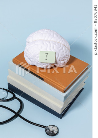 brain health and dementia series_stacked books and brain miniature, stethoscope 98076943