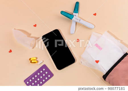 woman menstrual products_smartphone and sanitary pad woman menstrual products_smartphone and sanitary pad 98077181