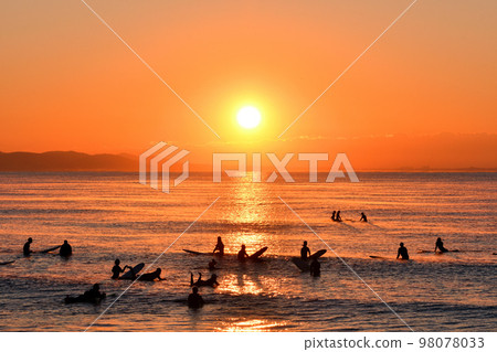Surfer watching the first sunrise of the year (silhouette) Surfer watching the first sunrise of the year (silhouette) 98078033