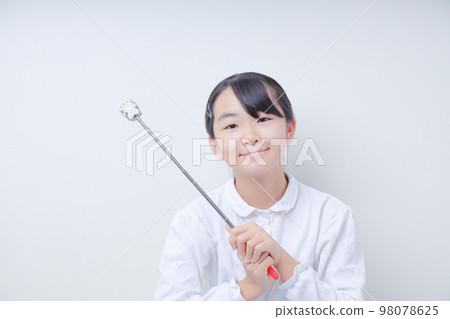 Female elementary school student smiling with a pointer with both hands 98078625