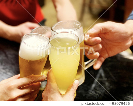 四個人的手用果汁和啤酒敬酒 98079436