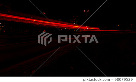 Lights of cars at night. Street line lights. Night highway city. Long exposure photograph night road. Colored bands of red light trails on the road. Background wallpaper defocused  98079529
