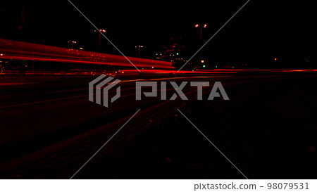 Lights of cars at night. Street line lights. Night highway city. Long exposure photograph night road. Colored bands of red light trails on the road. Background wallpaper defocused  98079531