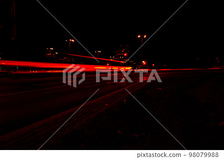 Lights of cars at night. Street line lights. Night highway city. Long exposure photograph night road. Colored bands of red light trails on the road. Background wallpaper defocused  98079988