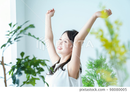 A woman who stretches out while bathing in the light by the window A woman who stretches out while bathing in the light by the window 98080005