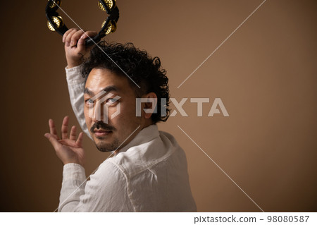 Image of a mysterious tambourine player 98080587