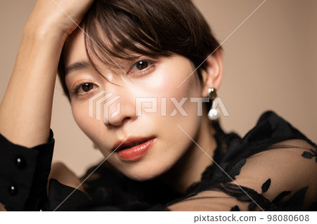 Close-up of a beautiful woman in a dress looking at the camera 98080608