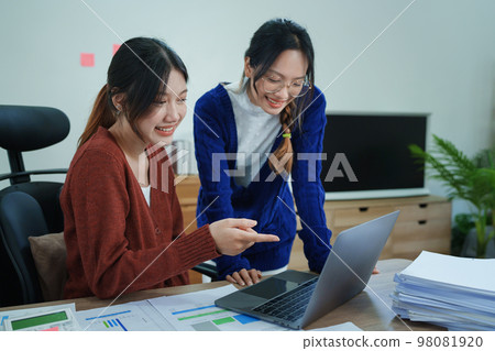 Financial analysts analyzing business reports on planned investment projects during corporate meeting discussions showcase successful teamwork with marketing plan, computers and documents to work. Financial analysts analyzing business reports on planned investment projects during corporate meeting discussions showcase successful teamwork with marketing plan, computers and documents to work. 98081920