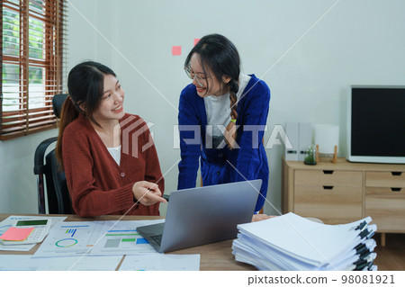 Financial analysts analyzing business reports on planned investment projects during corporate meeting discussions showcase successful teamwork with marketing plan, computers and documents to work. 98081921