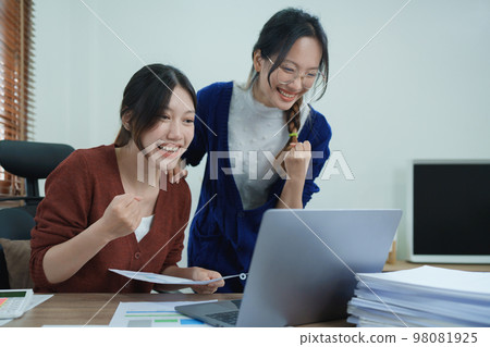 Financial analysts analyzing business reports on planned investment projects during corporate meeting discussions showcase successful teamwork with marketing plan, computers and documents to work. 98081925