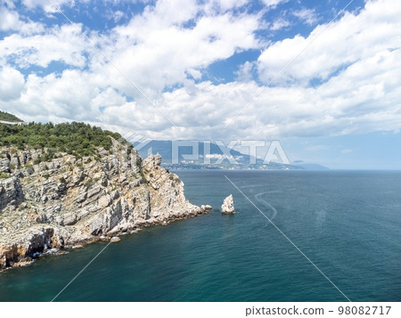 aerial photo of rock Parus Sail and Ayu-Dag Bear Mountain and near Gaspra, Yalta, Crimea at bright sunny day over the Black sea. Rock Parus in Gaspra near Swallow's nest in Crimea. 98082717