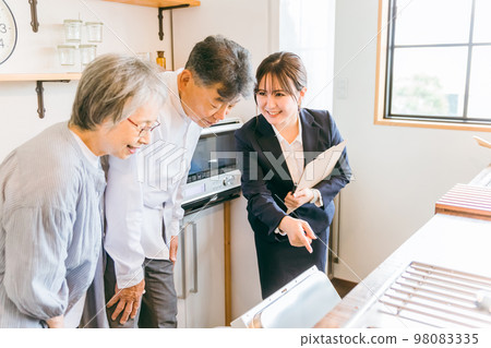 Asian business woman (dishwasher) explaining to an elderly couple at a housing exhibition hall, model room, house maker 98083335