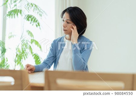 Middle-aged woman thinking in the living room 98084550