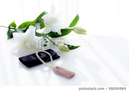 Taking pictures of rosary and lily flowers 98084969