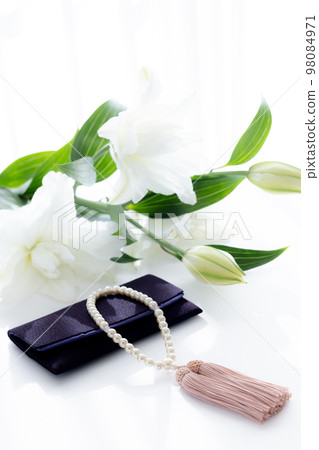 Taking pictures of rosary and lily flowers 98084971
