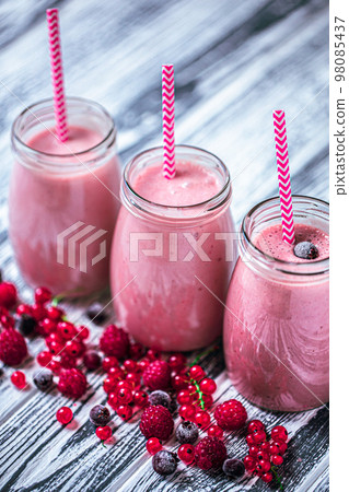 From above shot of three tasty milkshakes in glasses jars made from raspberry, blueberries, currant From above shot of three tasty milkshakes in glasses jars made from raspberry, blueberries, currant 98085437