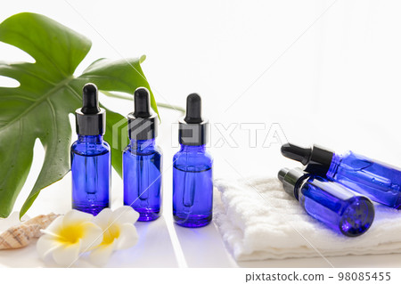 Aroma oil bottles and monstera leaves 98085455