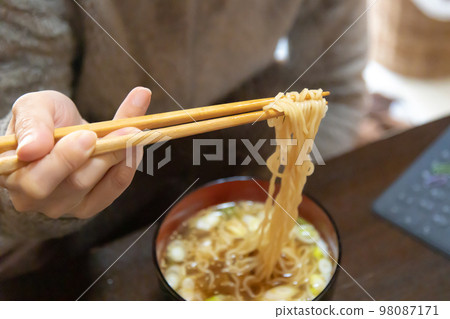 A woman eating instant noodles The way she holds her chopsticks is strange 98087171