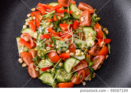 Delicious juicy fresh salad of tomatoes, peppers, cucumber, microgreens and sprouted  mung bean 98087189