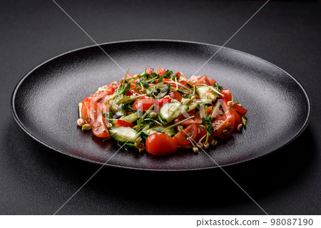 Delicious juicy fresh salad of tomatoes, peppers, cucumber, microgreens and sprouted mung bean Delicious juicy fresh salad of tomatoes, peppers, cucumber, microgreens and sprouted mung bean 98087190