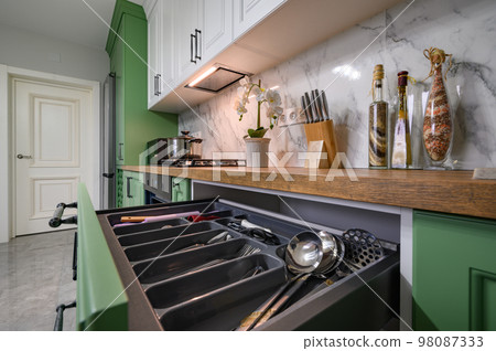 Pulled out drawer wih kitchen utensils at new green kitchen 98087333