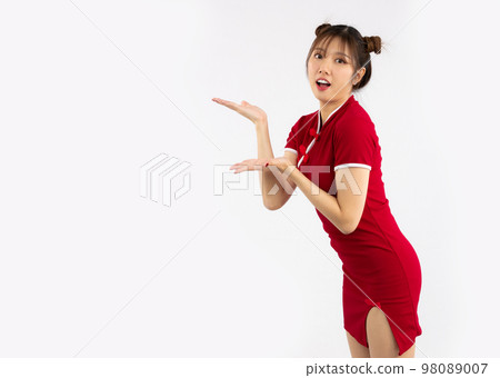Chinese new year concept. Young Asian woman wearing red traditional chinese dress with gesture of introduce isolated on white background.. 98089007
