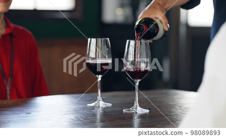 sommelier pouring wine into glass 98089893