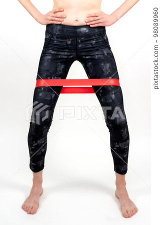 Legs of woman during fitness workout with rubber resistance band Legs of woman during fitness workout with rubber resistance band 98089960