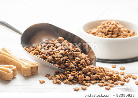 Dry pet food in scoop on white wooden background. 98090928