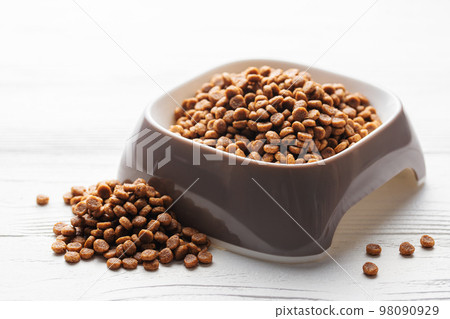 A bowl of dog food on a wooden floor. A bowl of dog food on a wooden floor. 98090929