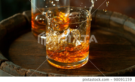 Close-up of pouring whiskey or rum on old wooden barrel 98091159