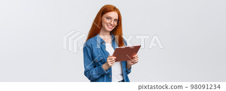Professionalism, work and people concept. Young cheerful attractive female redhead in glasses, holding digital tablet and smiling at camera with happy confident expression over white background Professionalism, work and people concept. Young cheerful attractive female redhead in glasses, holding digital tablet and smiling at camera with happy confident expression over white background 98091234