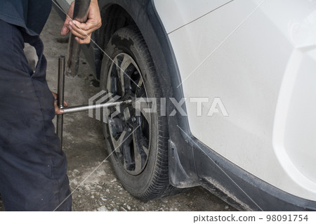 Car mechanic changing wheels in car,Tire repairer 98091754
