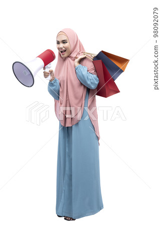 Asian Muslim woman in veil holding megaphone and shopping bags 98092079