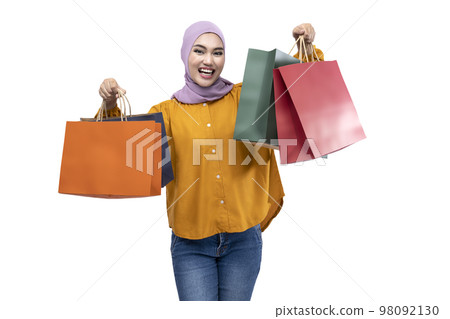 Asian Muslim woman in a headscarf holding shopping bags Asian Muslim woman in a headscarf holding shopping bags 98092130
