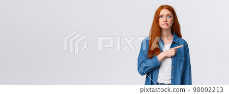 Anxious and worried cute girl having first day new college, biting lip guilty or nervous, having insecure feeling, looking scared camera, pointing finger right, standing white background Anxious and worried cute girl having first day new college, biting lip guilty or nervous, having insecure feeling, looking scared camera, pointing finger right, standing white background 98092213