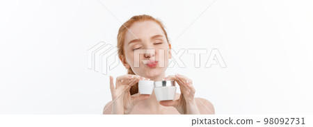 portrait of beautiful woman smiling while taking some facial cream isolated on white background with copy space. 98092731