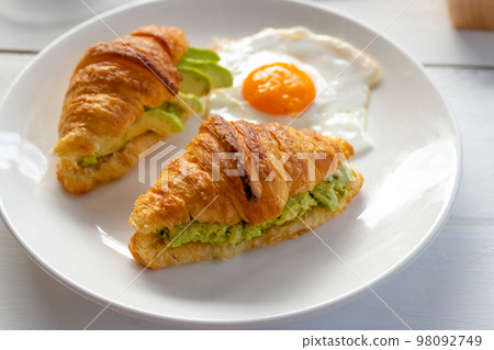 Croissant sandwich with egg, avocado on white dish. breakfast and healthy food concept. 98092749