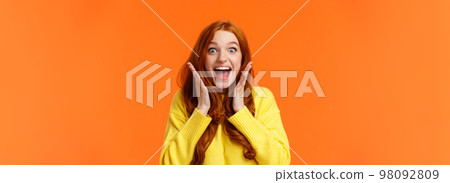 Excitement, emotions and holidays concept. Waist-up shot cheerful impressed and excited redhead woman screaming from thrill and joy, hold hands near face, open mouth and glance amazed Excitement, emotions and holidays concept. Waist-up shot cheerful impressed and excited redhead woman screaming from thrill and joy, hold hands near face, open mouth and glance amazed 98092809